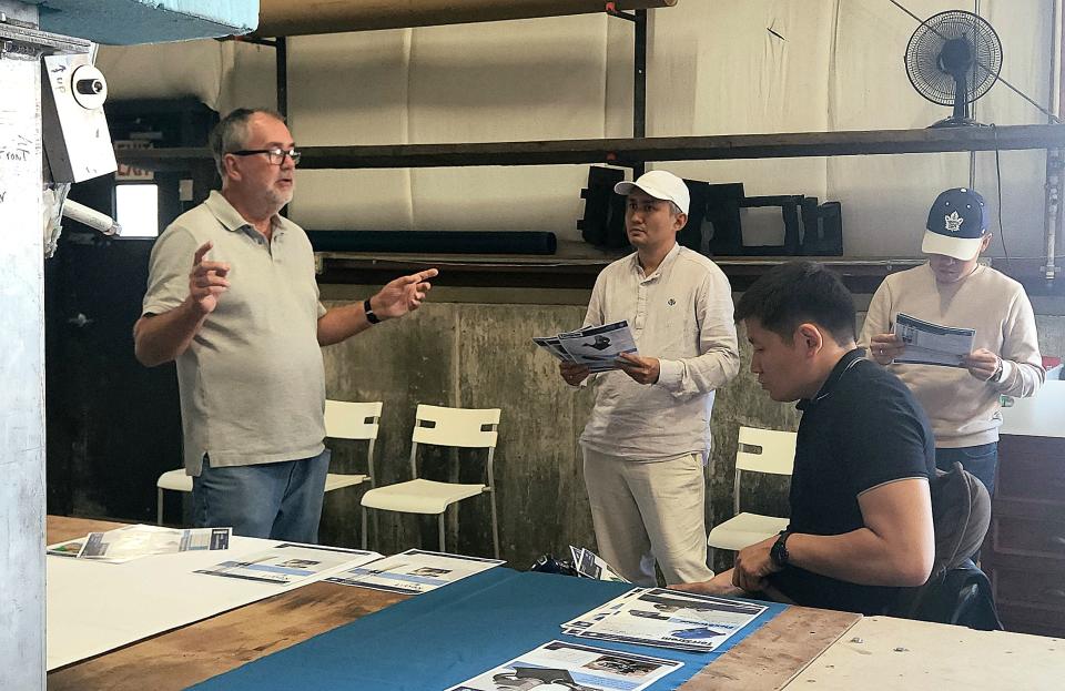 Eben Franks, director of prototyping and instrumentation for Littoral Power Systems, Inc. and LPS Hydro Solutions, speaks to Kyrgyzstani delegates Nurlan Kalybekov, Mirbek Asangariev and Bekmurzaw Nursultan about his work during their visit to New Bedford Research & Robotics on Wednesday.