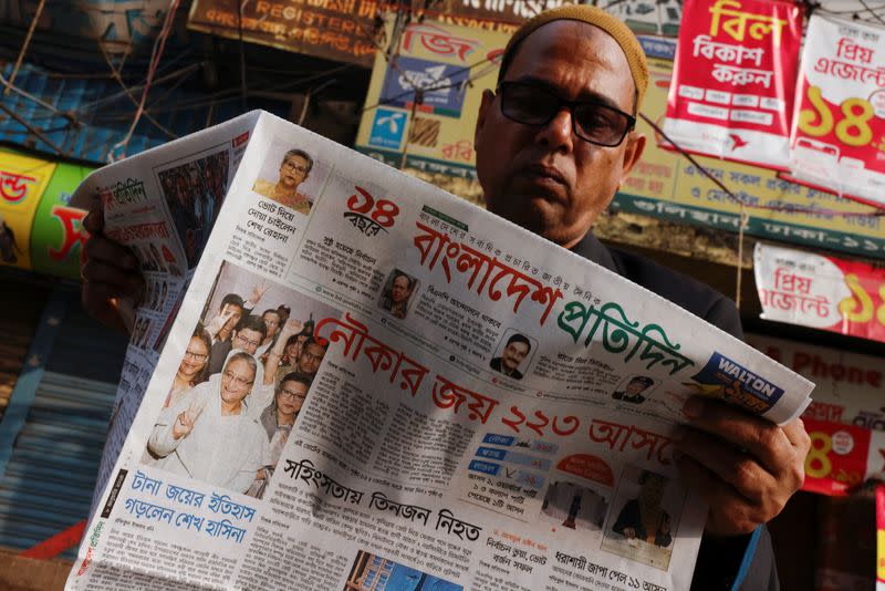 A man reads a newspaper the morning after Bangladesh Awami League won the 12th general election, in Dhaka