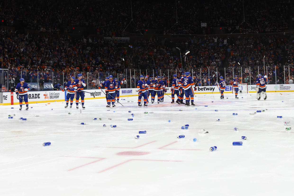 UNIONDALE, NEW YORK - JUNE 23:  The New York Islanders wave to the fans as beer cans are thrown on the ice after their 3-2 overtime victory against the Tampa Bay Lightning in Game Six of the Stanley Cup Semifinals during the 2021 Stanley Cup Playoffs at Nassau Coliseum on June 23, 2021 in Uniondale, New York. (Photo by Bruce Bennett/Getty Images)