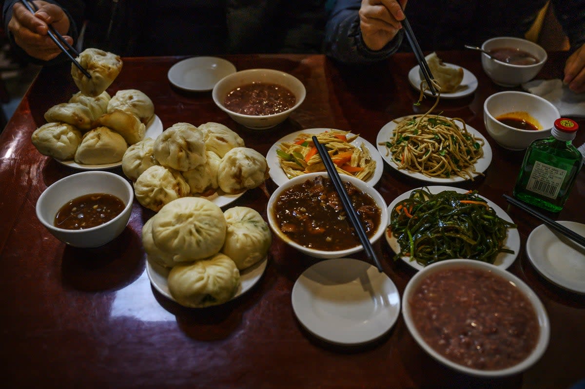 Representative:  Dishes of steamed buns and stew and other items are seen on the table at local restaurant  (Getty Images)