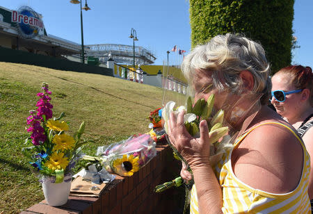 Members of the public react as they leave floral tributes outside the main entrance to Dreamworld located on the Gold Coast, Australia, October 26, 2016 after Tuesday's tragedy that saw four people killed on the Thunder River Rapids Ride at Australia's biggest theme park. AAP/Dave Hunt/via REUTERS