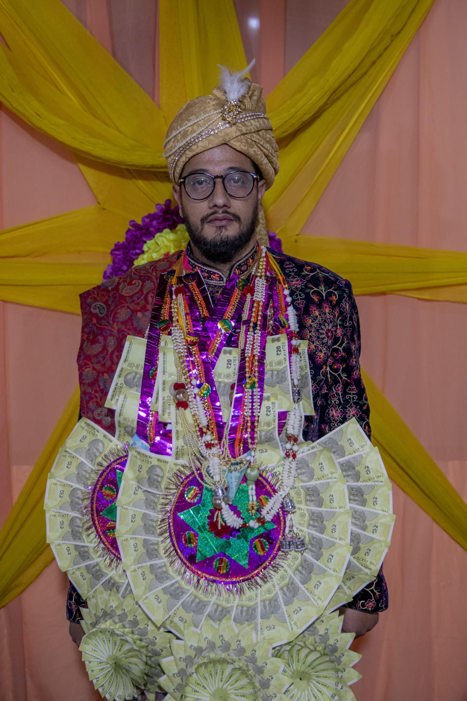 Saqib Fazili, a Kashmiri groom poses for photograph during a wedding ceremony on the outskirts of Srinagar, Indian controlled Kashmir, Wednesday, Sept. 16, 2020. The coronavirus pandemic has changed the way people celebrate weddings in Kashmir. The traditional week-long feasting , elaborate rituals and huge gatherings have given way to muted ceremonies with a limited number of close relatives attending. With restrictions in place and many weddings cancelled, the traditional wedding chefs have little or no work. The virus has drastically impacted the life and businesses in the region. (AP Photo/ Dar Yasin)