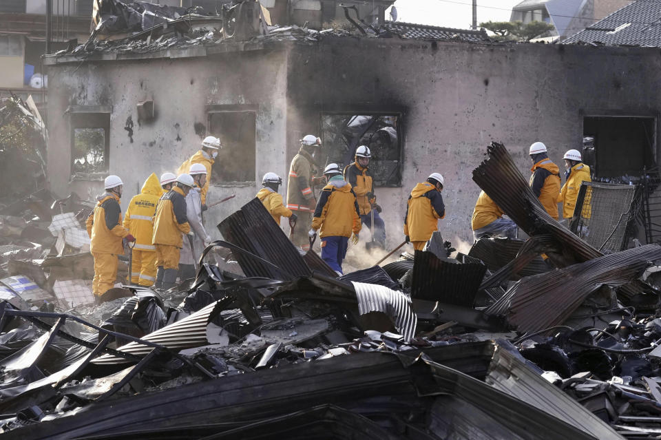 Firefighters remove the debris from a fire at a burnt market in Wajima, Ishikawa prefecture, Japan Saturday, Jan. 6, 2024. A series of powerful quakes set off a large fire in the town of Wajima, as well as tsunamis and landslides in the region. (Kyodo News via AP)