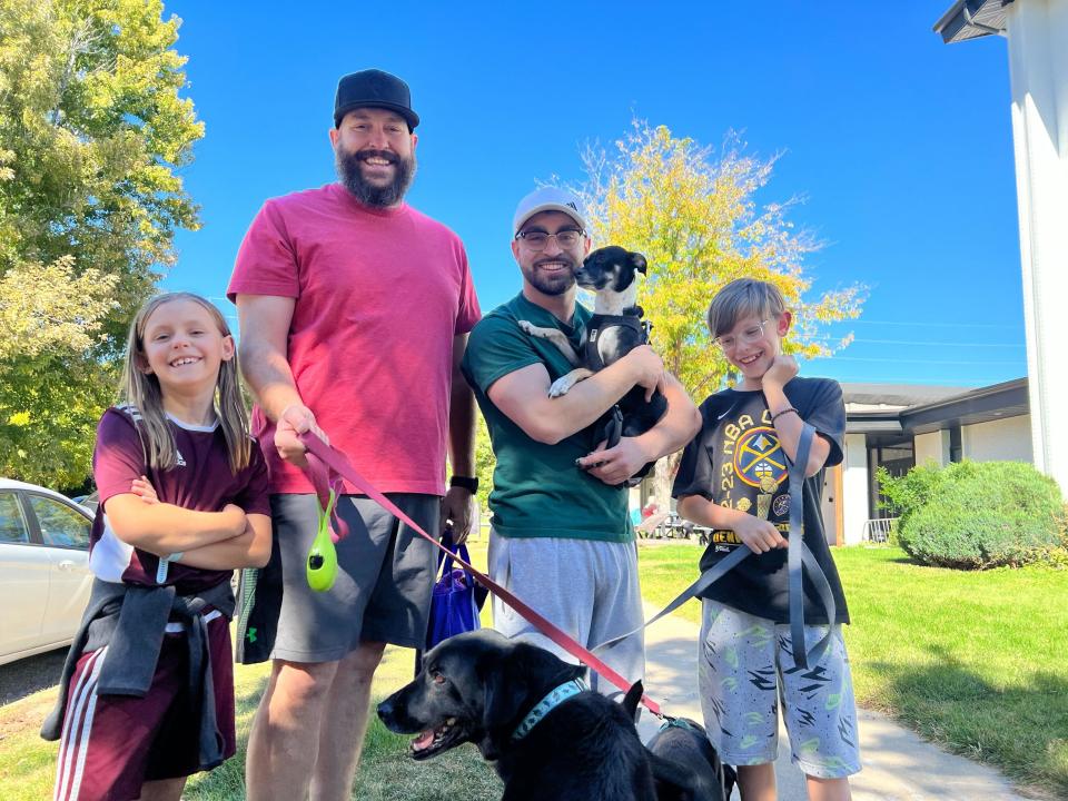 Ben Cochell (center) with his children and Pawsitive Recovery participant Ethan. Ethan holds his dog, Dexter, who Cochell fostered, while Cochell holds the leash for his own dog, Snowflake.  / Credit: Ben Cochell