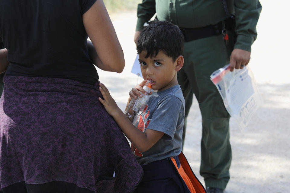 Central Americans seeking asylum wait as U.S. Border Patrol agents take them into custody on June 12, 2018, near McAllen, Texas.