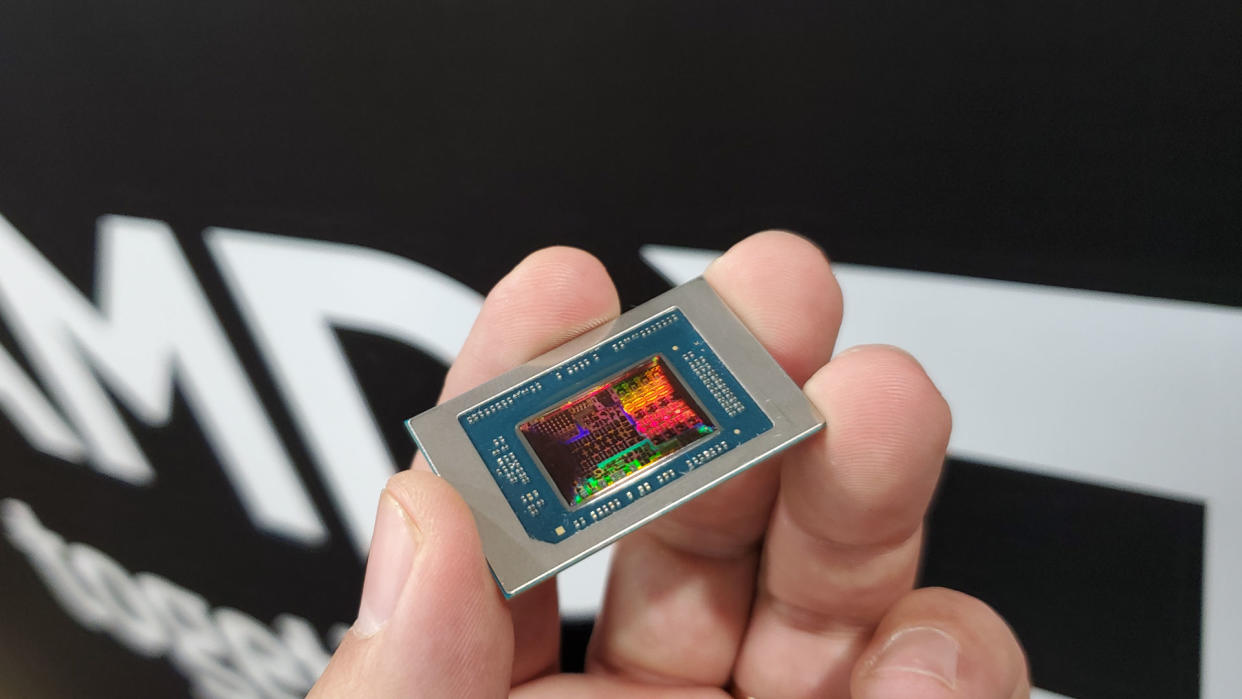  AMD Strix Point APU chip, held in a hand, with the reflected light showing the various processing blocks in the chip die. 