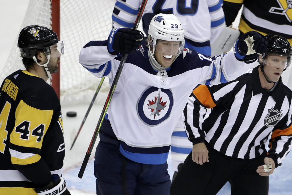 Winnipeg Jets' Patrik Laine (29) celebrates after assisting on a goal by Ville Heinola during the first period of an NHL hockey game against the Pittsburgh Penguins in Pittsburgh, Tuesday, Oct. 8, 2019. (AP Photo/Gene J. Puskar)