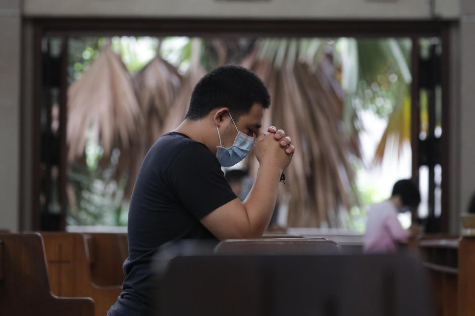 A man prays with only a few other parishioners as a measure to prevent the spread of COVID19 during Mass at the Our Lady of Consolation Parish on Sunday, Aug. 2, 2020, in Quezon city, Philippines. Coronavirus infections in the Philippines continues to surge Sunday as medical groups declared the country was waging a losing battle against the contagion and asked the president to reimpose a lockdown in the capital. (AP Photo/Aaron Favila)