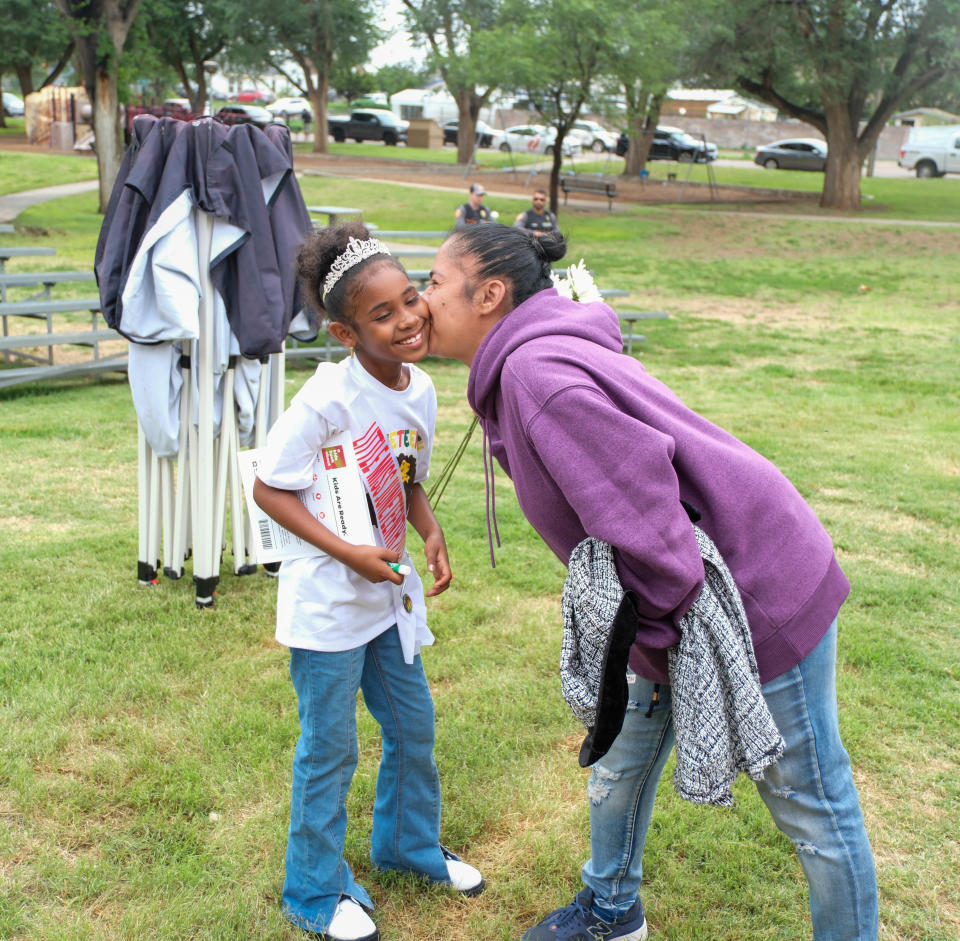 Blanca Masias receives a flower from her daughter and Little Miss Juneteenth Angelisa Harper Wednesday at the marker ceremony for Bones Hooks at Bones Hooks Park in Amarillo.