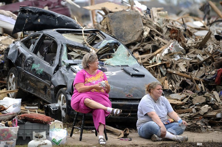 Tornado victims have lunch sitting amongst the rubble of their home in Moore, Oklahoma, on May 25, 2013