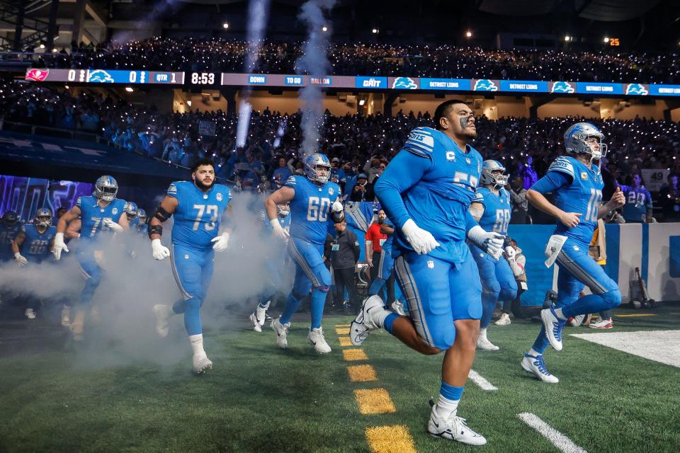 Detroit Lions offensive tackle Penei Sewell and quarterback Jared Goff lead the offensive players out of the tunnel as the team takes the field vs. the Tampa Bay Buccaneers in the NFC divisional round playoff game at Ford Field in Detroit on Sunday, Jan. 21, 2024.