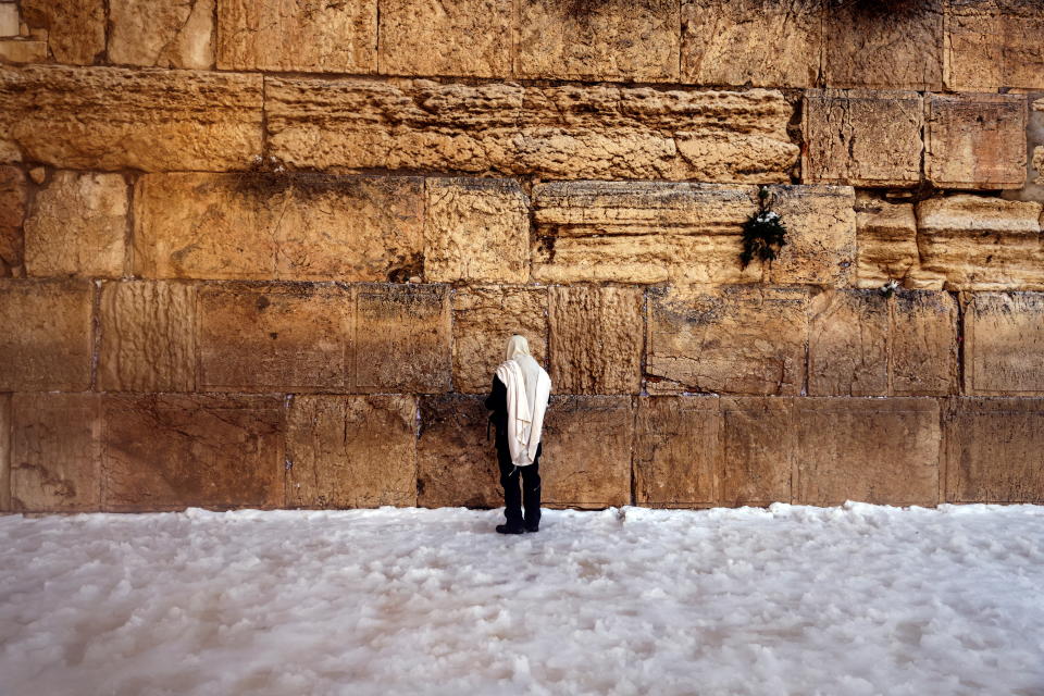 <p>An ultra-Orthodox Jewish man prays at the Western Wall, Judaism's holiest prayer site, on a snowy morning in Jerusalem's Old City, January 27, 2022. REUTERS/Ronen Zvulun</p>
