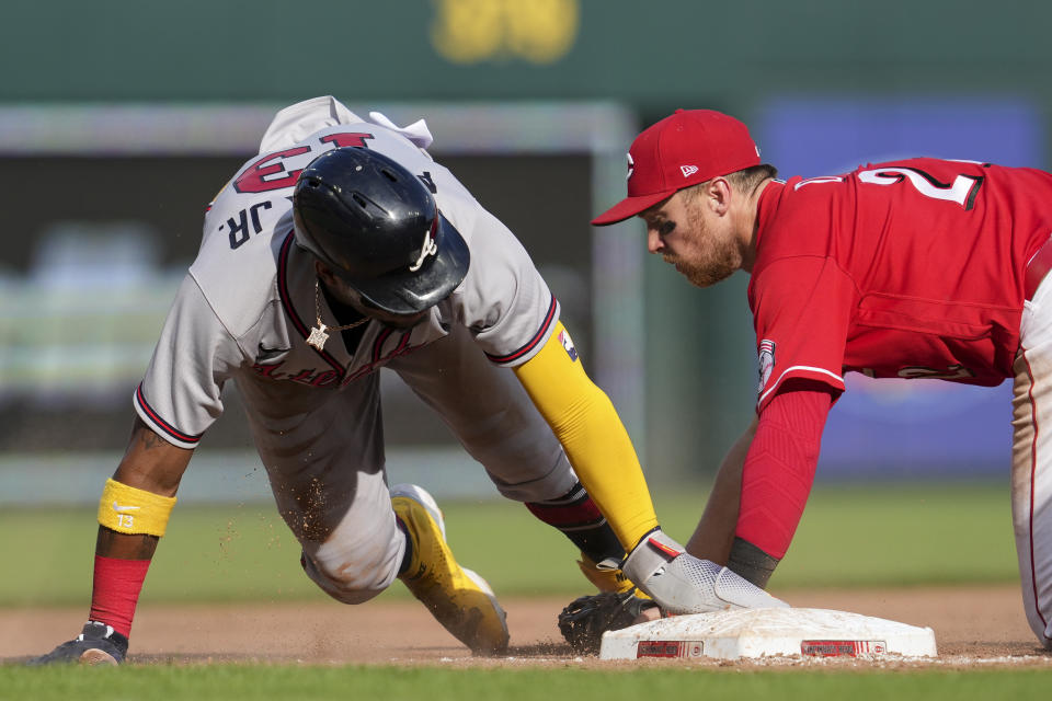 Atlanta Braves' Ronald Acuna Jr. (13) reaches third base on a single by Dansby Swanson, next to Cincinnati Reds third baseman Brandon Drury during the seventh inning of a baseball game Saturday, July 2, 2022, in Cincinnati. (AP Photo/Jeff Dean)