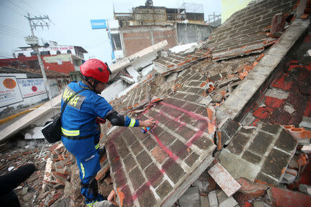 A rescue worker marks debris in the city of Juchitan, after an earthquake struck the southern coast of Mexico late on Thursday, in Mexico September 10, 2017. REUTERS/Edgard Garrido