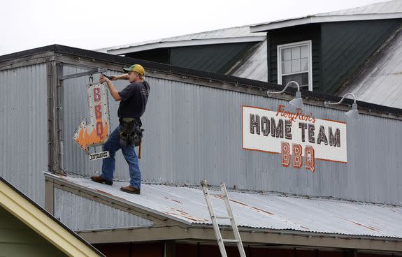 Troy Cooper takes down a restaurant sign at Home Team BBQ in preparation for Hurricane Matthew on Sullivan's Island, South Carolina, on Oct. 6.