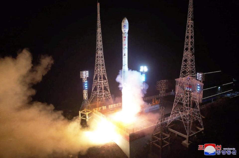 A rocket is seen mid-launch, with flame and a cloud of smoke at its base, and two pylons either side against a dark background. The image, released by North Korean news agency KCNA, purports to show the launch of the rocket carrying a spy satellite Malligyong-1 in North Gyeongsang Province, North Korea, released on November 21, 2023.