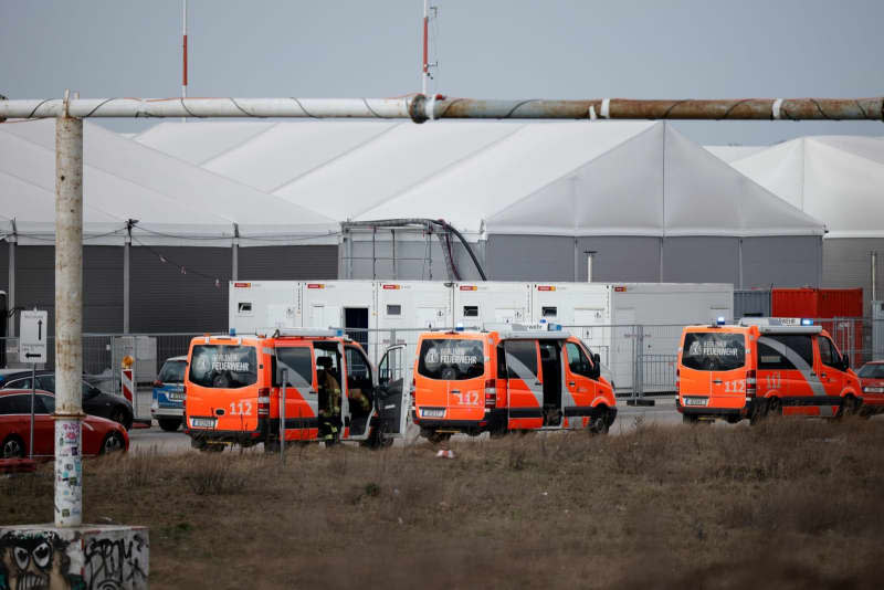 Firefighters are deployed to the refugee accommodation at the former Tegel Airport after a fire broke out. Sebastian Gollnow/dpa