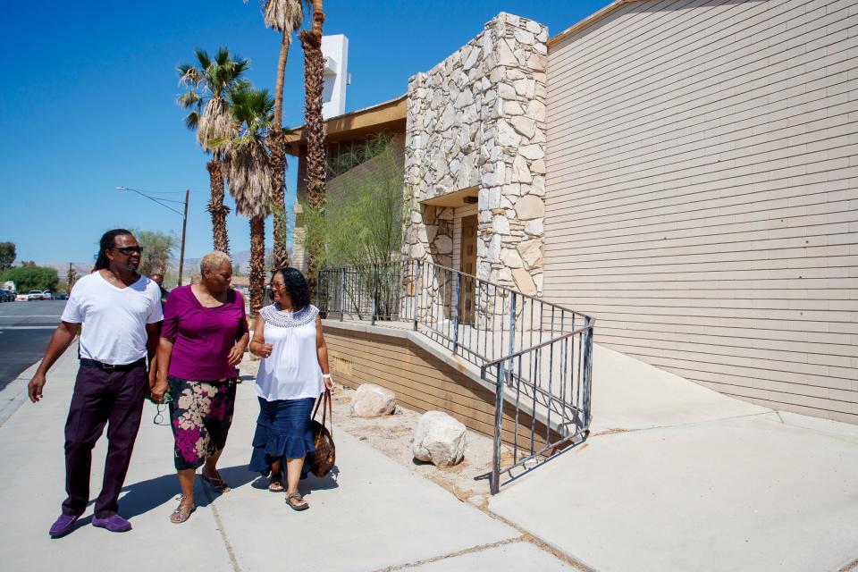 First Community Baptist Church members Jesse Hill, left, Maunaloa Hill, and Crystal Baylark walk outside the church in Desert Hot Springs, Calif., August 10, 2022. An April fire destroyed parts of the church building. Members continue to meet mostly virtually as they celebrate the 75th anniversary of the church later this month. 