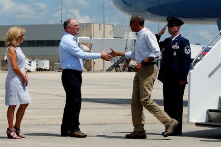 Louisiana Governor John Bel Edwards (2nd L) and his wife Donna (L) greet U.S. President Barack Obama as he arrives aboard Air Force One at Baton Rouge Metropolitan Airport in Baton Rouge, Louisiana, U.S., August 23, 2016. REUTERS/Jonathan Ernst