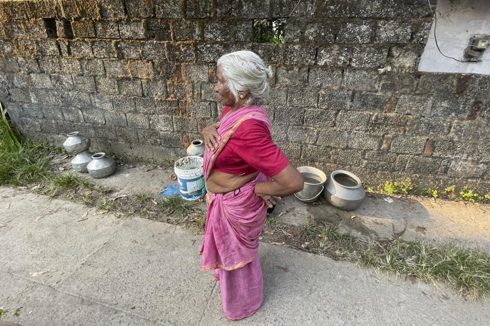 Maryamma Pillai takes a brief break from carrying pots of water to her home in the Chellanam area of Kochi, Kerala state, India, on March 1, 2023. Pillai is among residents who wait on a truck nearly every day to get clean water. (Uzmi Athar/Press Trust of India via AP)