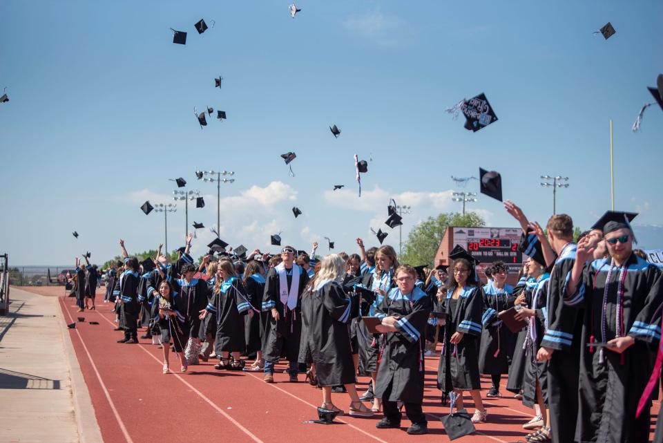 Pueblo West High School graduates toss their caps at the conclusion of their commencement ceremony on Friday, May 26, 2023.