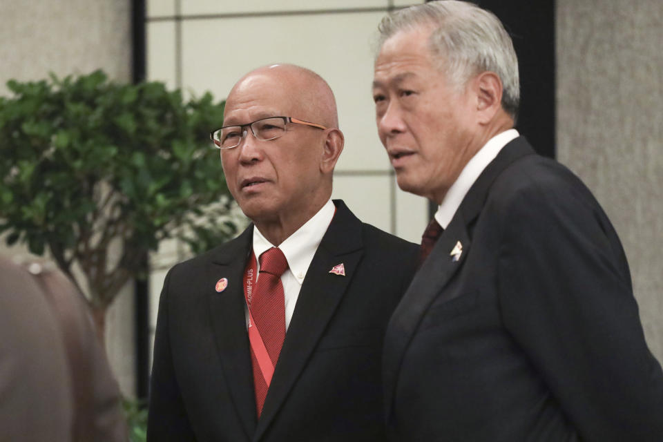 Philippine Secretary of National Defense Delfin N. Lorenzana, left, and Singapore's Defense Minister Ng Eng Hen attend a breakfast session for defense ministers at the 12th ASEAN Defence Ministers' Meeting in Singapore on Friday, Oct. 19, 2018. (AP Photo/Don Wong)