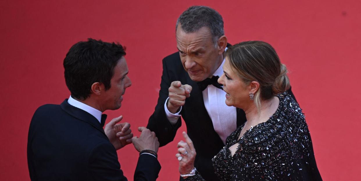 tom hanks pointing while he and wife rita wilson speak to a red carpet worker