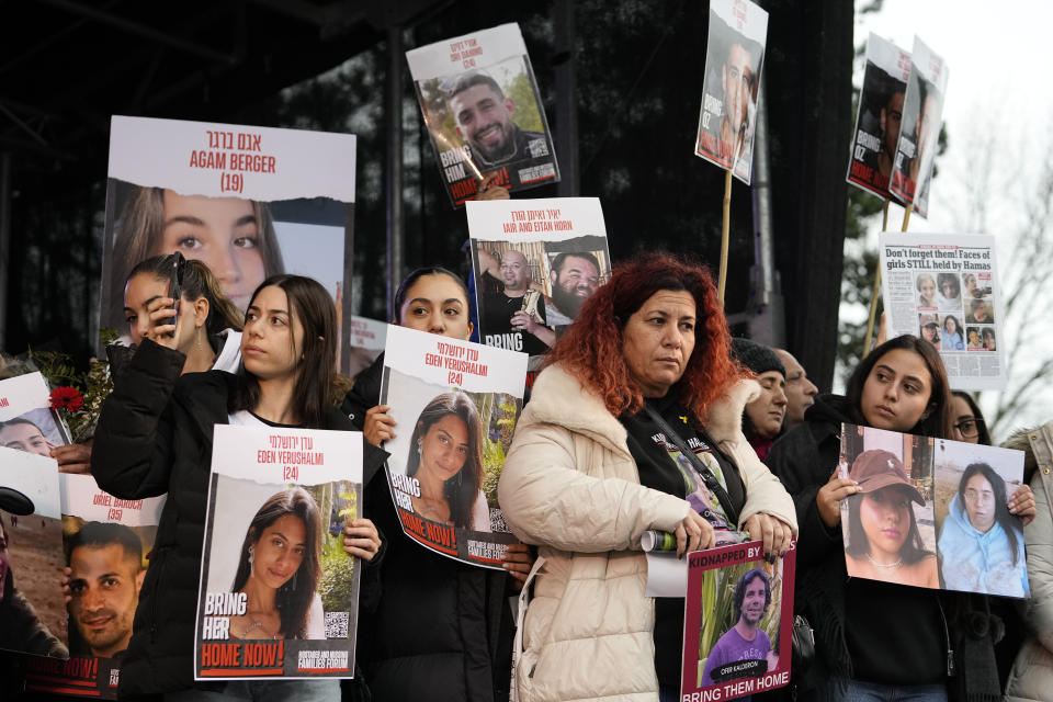 Families of hostages and former hostages hold images on a podium at a protest near the International Crime Court at The Hague, during a protest of representatives of families of hostages from the Oct. 7 cross-border attack by Hamas on Israel, in The Hague, Netherlands, Wednesday, Feb. 14, 2024. The Hostages Families Forum together with the Raoul Wallenberg Center for Human Rights is submitting a comprehensive complaint to the International Criminal Court on behalf of released hostages and families of hostages, including the issuance of arrest warrants for Hamas leaders on war crimes allegations including taking hostages, enforced disappearances, sexual violence and torture. (AP Photo/Martin Meissner)
