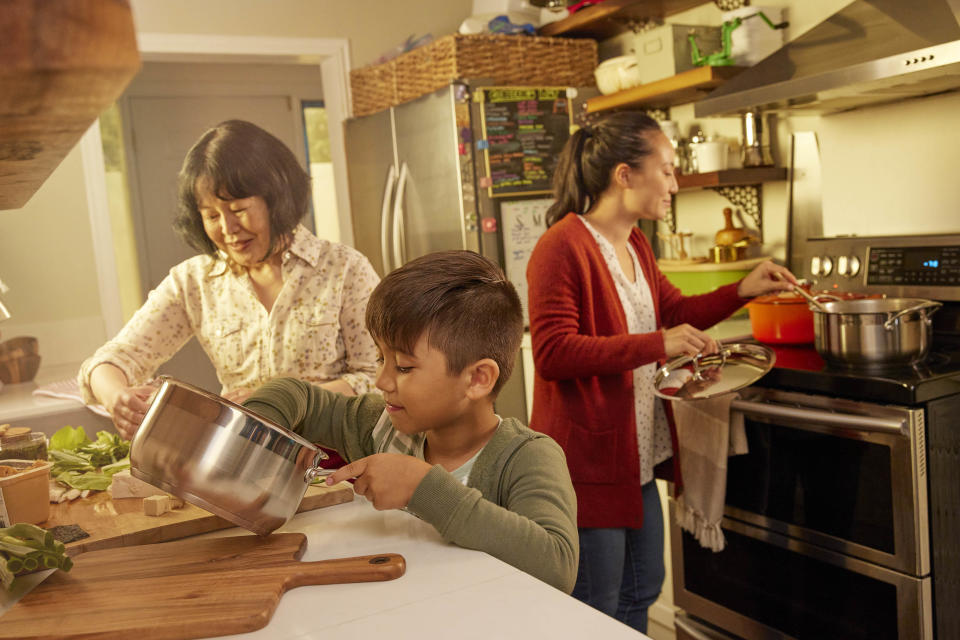 Child helps to prepare lunch with mother and grandmother