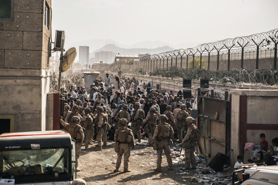 In this Aug. 21, 2021, photo provided by the U.S. Marines, U.S. Marines with Special Purpose Marine Air-Ground Task Force - Crisis Response - Central Command, provide assistance at an evacuation control checkpoint during an evacuation at Hamid Karzai International Airport in Kabul, Afghanistan. (Staff Sgt. Victor Mancilla/U.S. Marine Corps via AP)