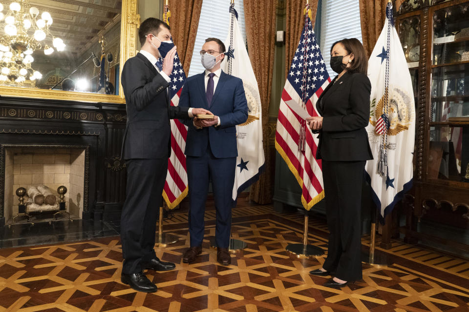 U.S. Vice President Kamala Harris, right, swears in Pete Buttigieg, U.S. secretary of transportation, left, during a ceremony with husband Chasten Buttigieg, center, in Washington, D.C., U.S., on Feb. 3, 2021. (Chris Kleponis/CNP/Bloomberg via Getty Images)