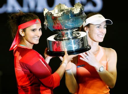 Switzerland's Martina Hingis (R) and India's Sania Mirza pose with the trophy after winning their doubles final match at the Australian Open tennis tournament at Melbourne Park, Australia, January 29, 2016. REUTERS/Thomas Peter