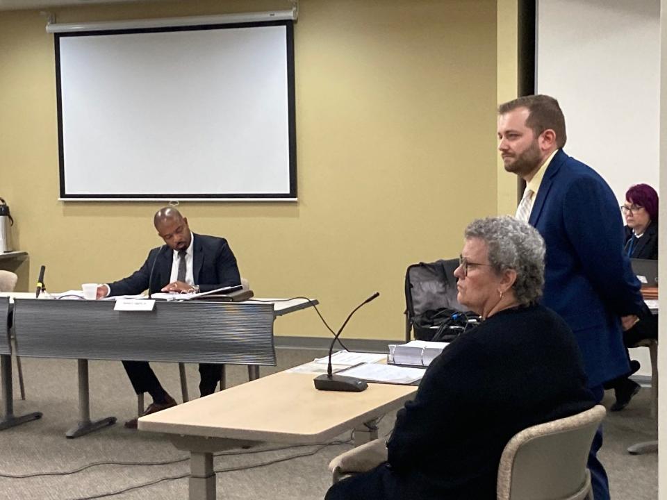 Deborah Mikula, in foreground, appears before the State Ethics Board Thursday, Sept. 7, 2023 with Assistant Attorney General Ryan Wier (standing). In the background is Ethics Board member James Liggins, Jr.