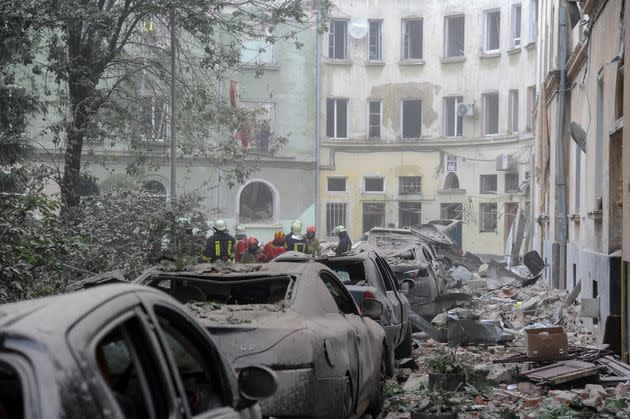 Сотрудники экстренных служб собираются возле поврежденных зданий, поскольку поиск жертв продолжается после российской ракетной атаки на Львов, Украина, в июле.