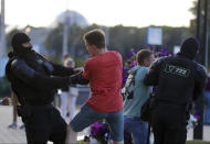 Police detain young protesters following presidential elections in Minsk, Belarus, Monday, Aug. 10, 2020. Thousands of people have protested in Belarus for a second straight night after official results from weekend elections gave an overwhelming victory to authoritarian President Alexander Lukashenko, extending his 26-year rule. A heavy police contingent blocked central squares and avenues, moving quickly to disperse protesters and detained dozens. (AP Photo/Sergei Grits)