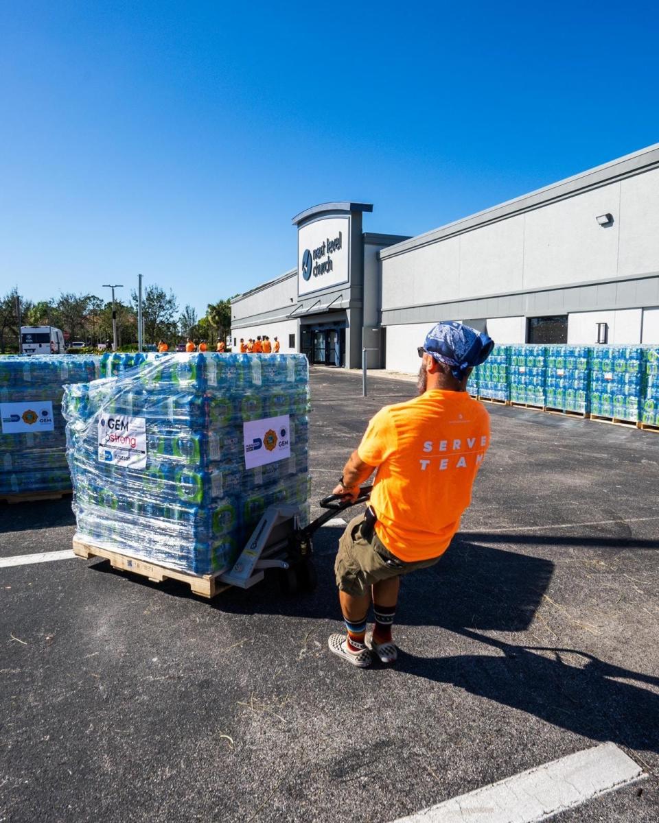 A worker moves a pallet of water provided for survivors of Hurricane Ian by Global Empowerment Mission, which has assisted in areas of Florida struck by Hurricane Ian. The organization is among the beneficiaries of donations raised through a fund established by the Town of Palm Beach United Way.