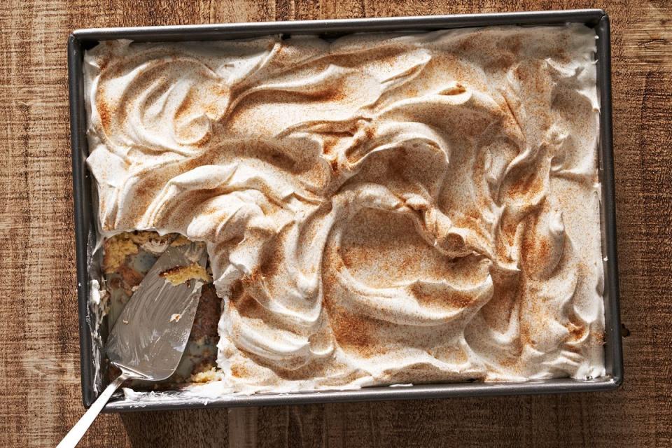 tres leches cake in a pan with a serving utensil