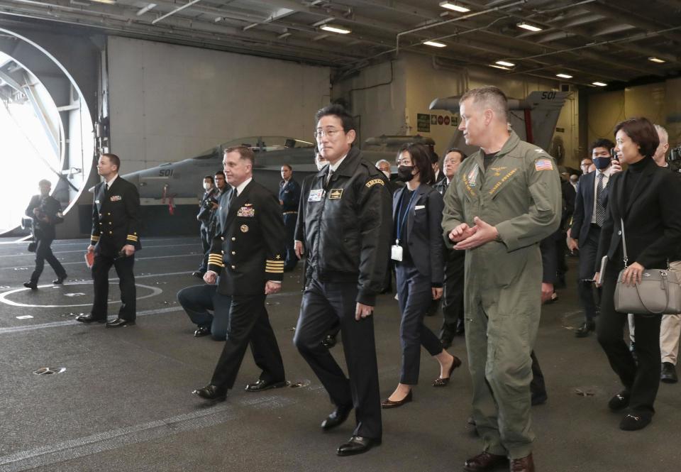 Japanese Prime Minister Fumio Kishida, center, visits the USS Ronald Reagan, in Sagami Bay, southwest of Tokyo, Sunday, Nov. 6, 2022. Kishida, at an international fleet review Sunday, said his country urgently needs to build up military capabilities as it faces worsening security environment in the East and South China Seas and threats from North Korea’s nuclear and missile advancement and Russia’s war on Ukraine.(Kyodo News via AP)