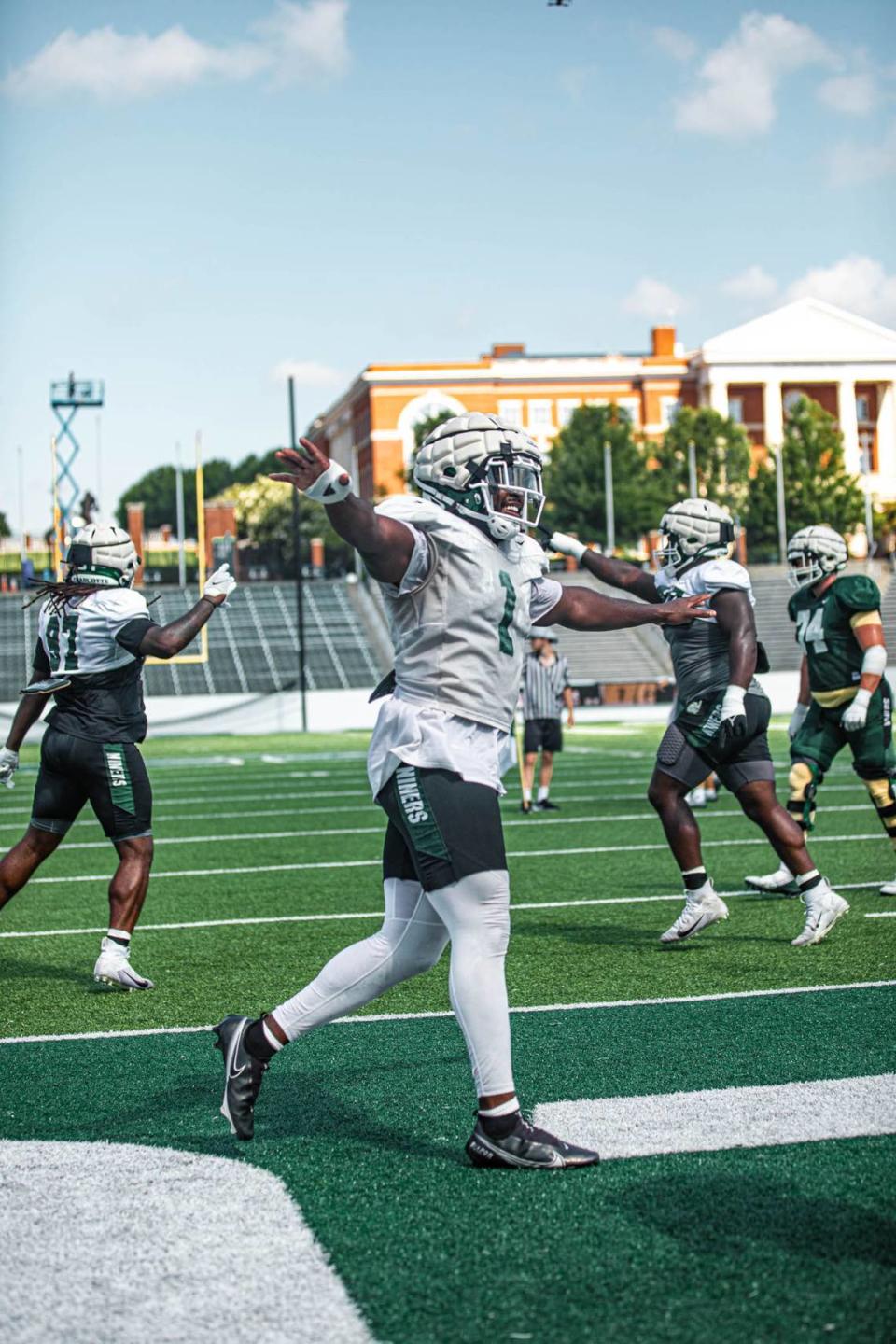 Charlotte 49ers defenders Amir Siddiq (1) and Jalar Holley (97) gesture during a drill earlier in the preseason. Charlotte 49ers Athletics/Charlotte 49ers Athletics