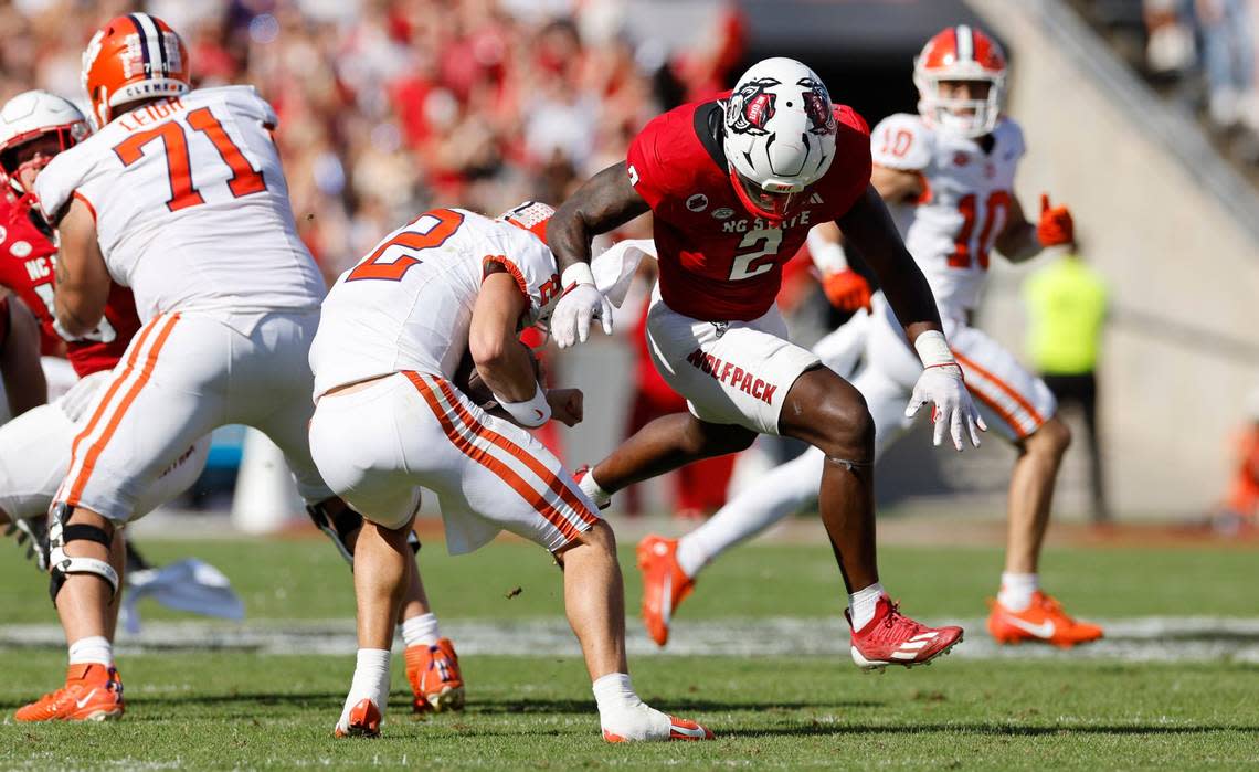 Clemson quarterback Cade Klubnik (2) escapes the sack attempt by linebacker Jaylon Scott (2) during the first half of N.C. State’s game against Clemson at Carter-Finley Stadium in Raleigh, N.C., Saturday, Oct. 28, 2023. Ethan Hyman/ehyman@newsobserver.com