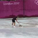 Workers sweep rainwater off a tarp on court 14 during a rain delay at the All England Lawn Tennis Club in Wimbledon, London at the 2012 Summer Olympics, Sunday, July 29, 2012. (AP Photo/Elise Amendola)