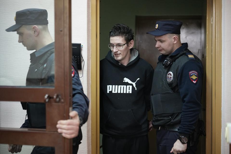 U.S. citizen Robert Woodland Romanov, center, is escorted into a glass cage prior to a court session on drug-related charges in Moscow, Russia, on Thursday, April 25, 2024. The U.S. citizen arrested on drug charges in Moscow amid soaring Russia-U.S. tensions has appeared in court. Robert Woodland Romanov is facing charges of trafficking large amounts of illegal drugs as part of an organized group — a criminal offense punishable by up to 20 years in prison. (AP Photo/Alexander Zemlianichenko)