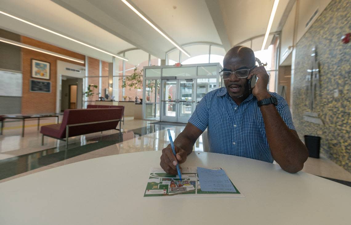 Nolan Ferguson, of University City, Missouri, makes calls to get help for David Semrau, a homeless senior citizen with a disability, in the lobby of Belleville City Hall on Thursday.