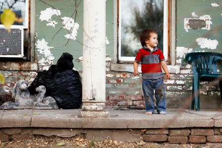 Kadin Mignery, 2, plays on the front porch of his home in St. Joseph, Missouri, U.S. November 15, 2016. REUTERS/Whitney Curtis