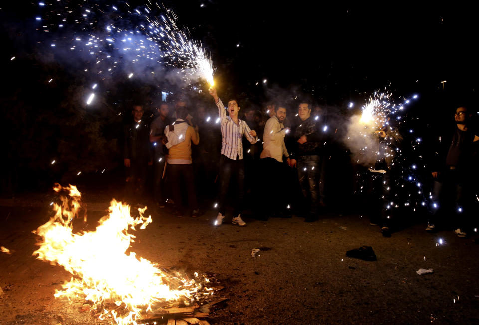 In this picture taken on Tuesday, March 18, 2014, Iranians light fireworks during a celebration, known as “Chaharshanbe Souri,” or Wednesday Feast, marking the eve of the last Wednesday of the solar Persian year, in Pardisan park, Tehran, Iran. The festival has been frowned upon by hard-liners since the 1979 Islamic revolution because they consider it a symbol of Zoroastrianism, one of Iran’s ancient religions of Iranians. They say it goes against Islamic traditions. (AP Photo/Vahid Salemi)