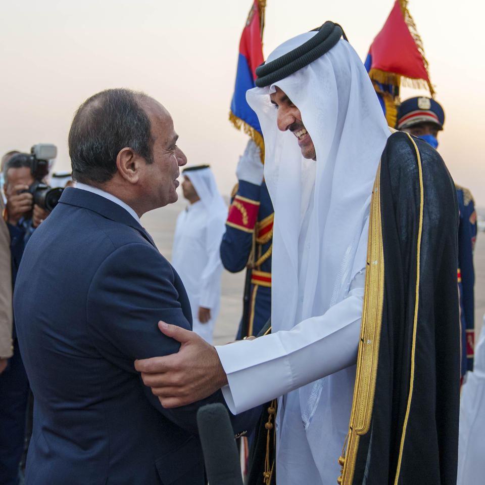 In this photo made available by Qatar News Agency, QNA, Qatari Emir Tamim bin Hamad Al Thani, right, is welcomed by Egyptian President Abdel-Fattah el-Sissi upon his arrival at Cairo airport, in Cairo, Egypt, Friday, June 24, 2022. Qatar's emir arrived to hold talks with Egypt's president in his first visit since the two countries agreed to reset relations after more than seven years of diplomatic animosity. (QNA via AP)