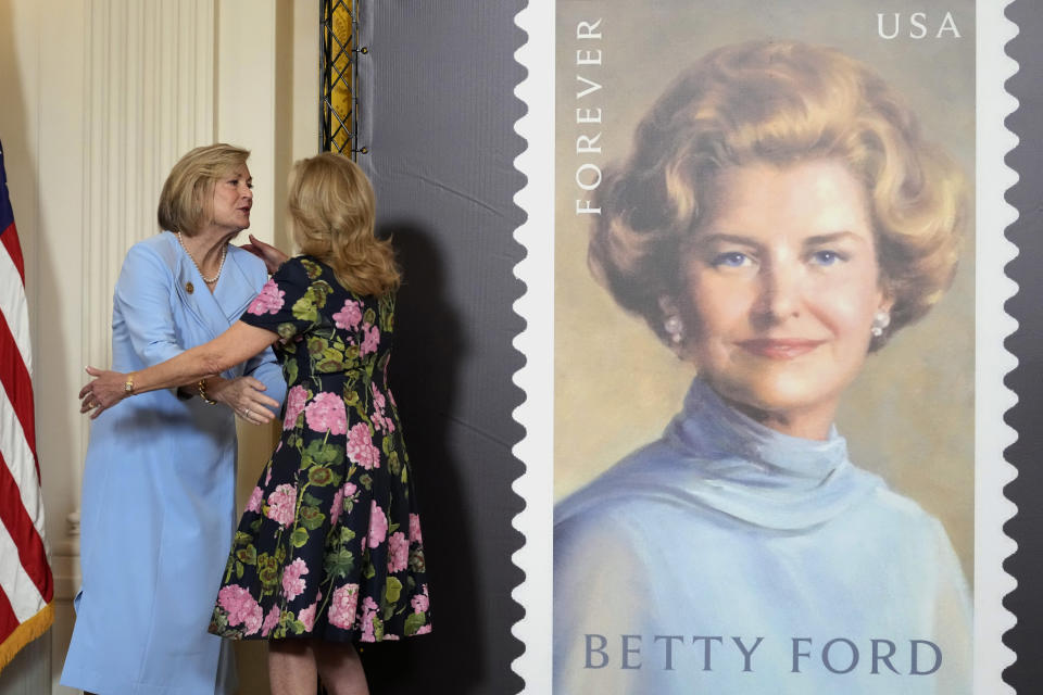First lady Jill Biden, right, and Susan Ford Bales, left, daughter of former first lady Betty Ford, hug in the East Room of the White House in Washington, Wednesday, March 6, 2024, during an unveiling of a new U.S. Postal Service stamp honoring former first lady Betty Ford. (AP Photo/Susan Walsh)