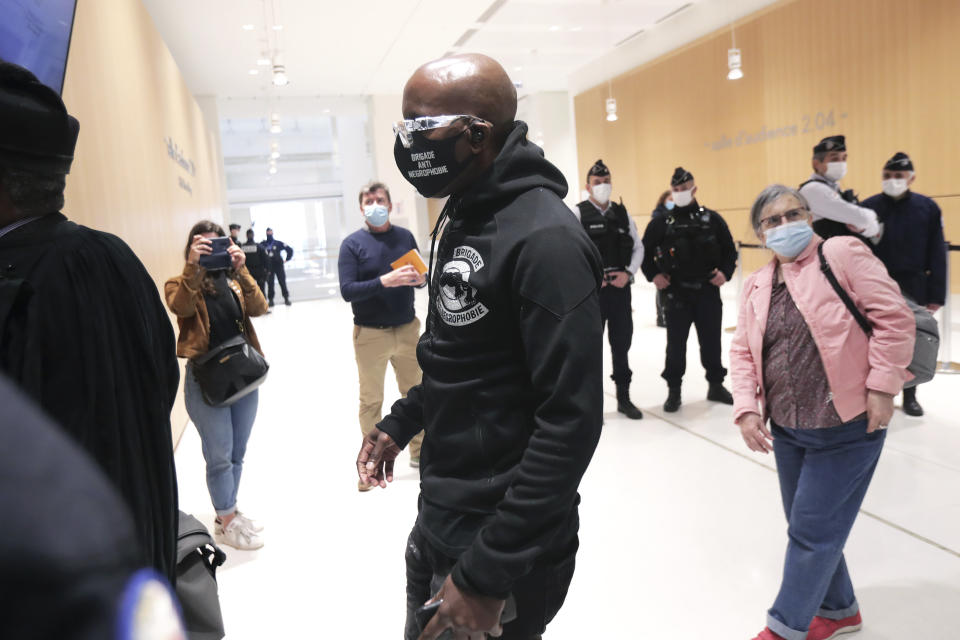 An activist from a group called the Anti-Negrophobia Brigade, Franco Lollia, wears a face mask reading « Anti-Negrophobia Brigade » as he arrives at the Paris courthouse, in Paris, May 10, 2021. Lollia stands accused of covering in graffiti a statue that honours Jean-Baptiste Colbert, a 17th century royal minister who wrote rules governing slaves in France's overseas colonies. (AP Photo/Thibault Camus)