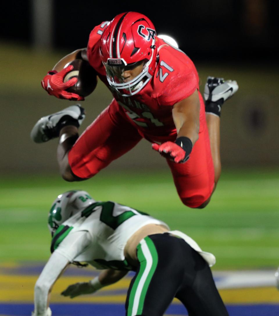 Carl Albert's Xavier Robinson leaps over a Bishop McGuinness defender during a Class 5A semifinal game in Noble on Nov. 24.