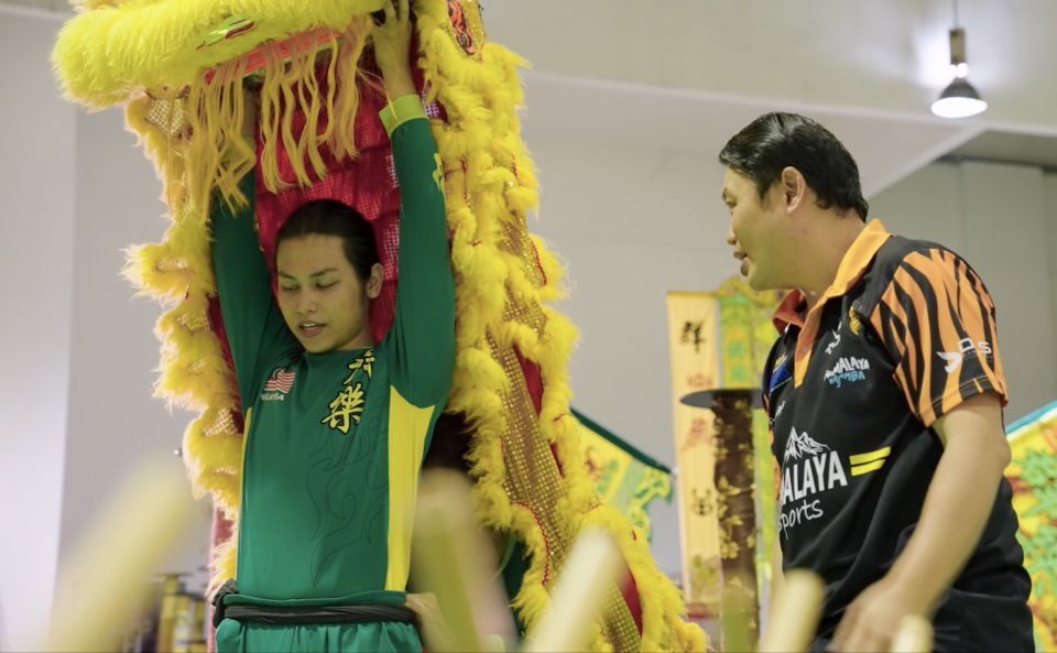 A malay man practicing lion dance routines with his coach.